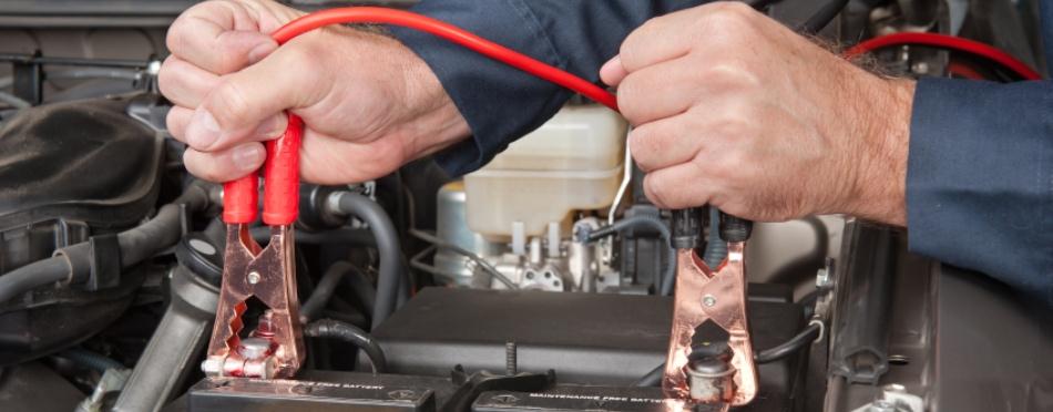 Jumper lead clamps held over a car battery