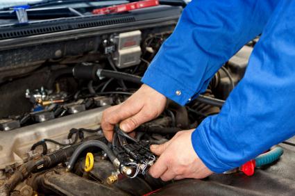 Hands working on wiring in an engine bay